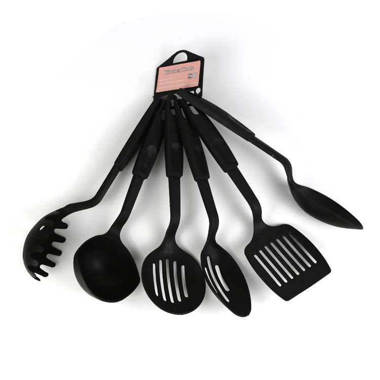Set of black kitchen utensils including a ladle, spoon, and spatula on a white background.