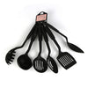 Set of black kitchen utensils including a ladle, spoon, and spatula on a white background.