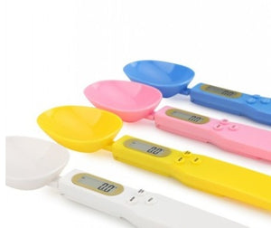 Colorful kitchen measuring tools including spoons, a scale, and digital rulers on a white background.