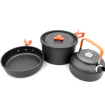 Set of black camping cookware with orange handles on a white background