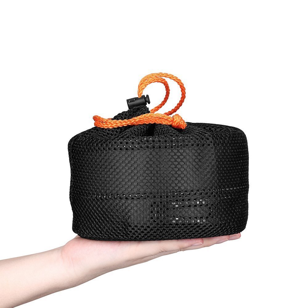 Black mesh bag with orange handle held in a hand on a white background
