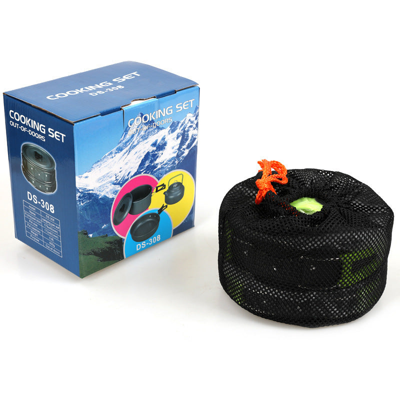 Cooking set packaging with a blue box featuring a mountain and cooking set imagery, next to a black mesh bag with colorful items.