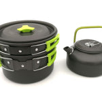 Black and green camping cookware set on a white background